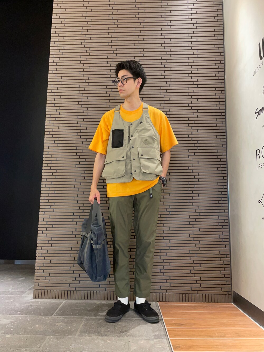 イエロー系のTシャツ/カットソー、ベージュ系のベスト、グリーン系のその他パンツを着用したメンズの夏コーディネートの1枚目の写真