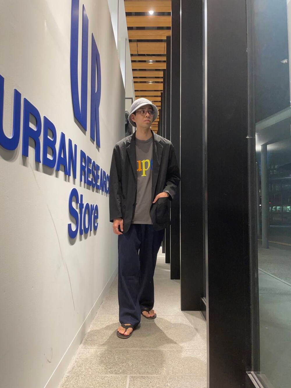 ブラック系のサンダル、ブラック系のその他アウター、ブルー系のデニムパンツを着用したメンズの夏コーディネートの1枚目の写真