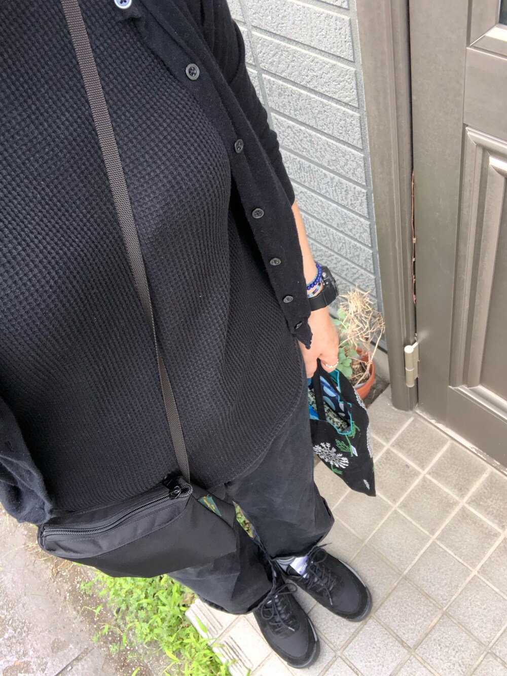 ブラック系のTシャツ/カットソー、ブラック系のカーディガン/ボレロ、ブラック系のデニムパンツを着用したレディースの秋コーディネートの1枚目の写真