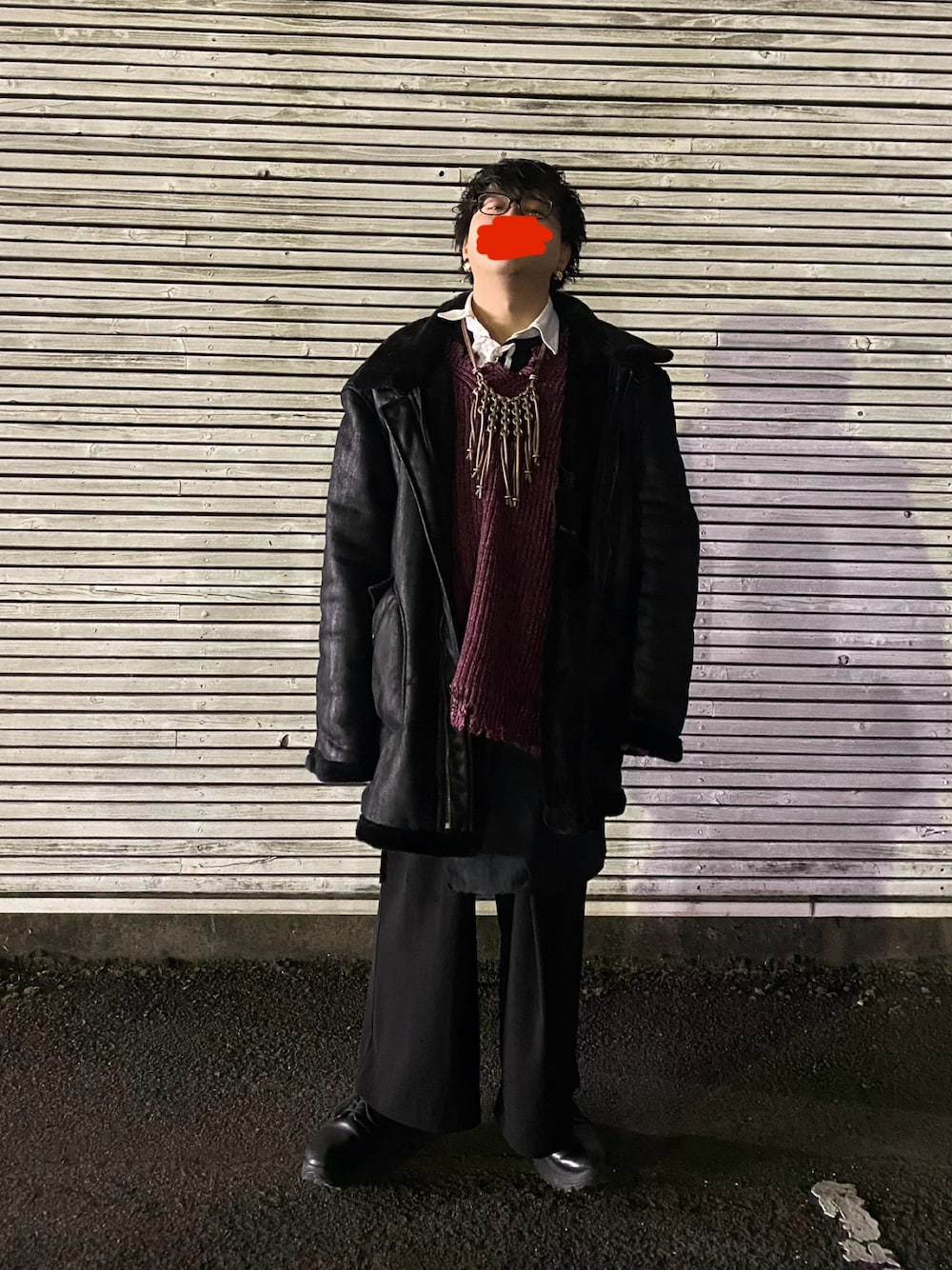 レッド系のニット/セーター、ブラック系のシャツ/ブラウス、ブラック系のムートンコートを着用したメンズの春コーディネートの1枚目の写真