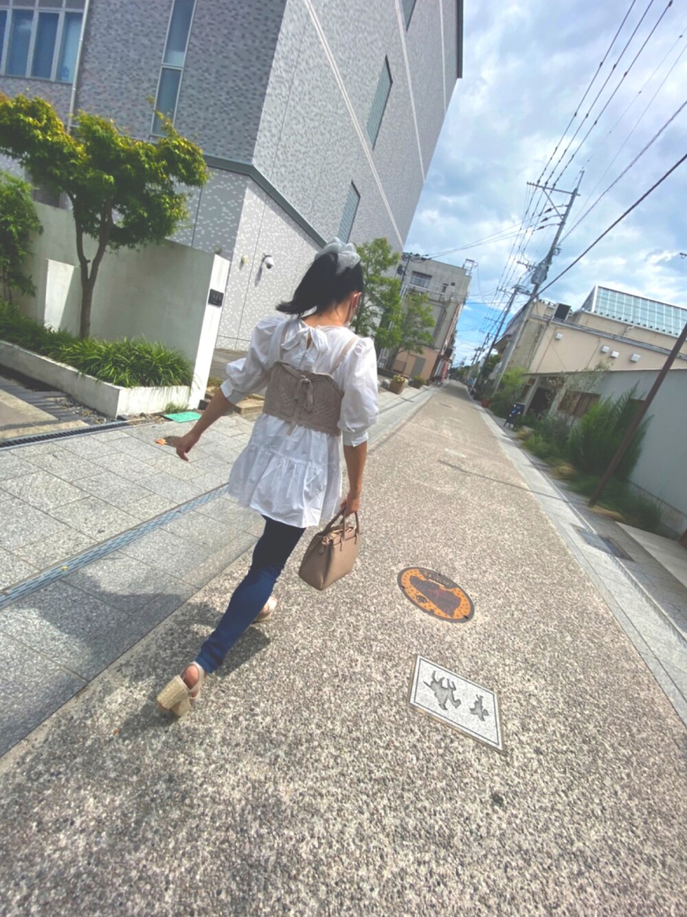 ブルー系のデニムパンツ、ベージュ系のベスト、ホワイト系のシャツ/ブラウスを着用したレディースの秋コーディネートの1枚目の写真