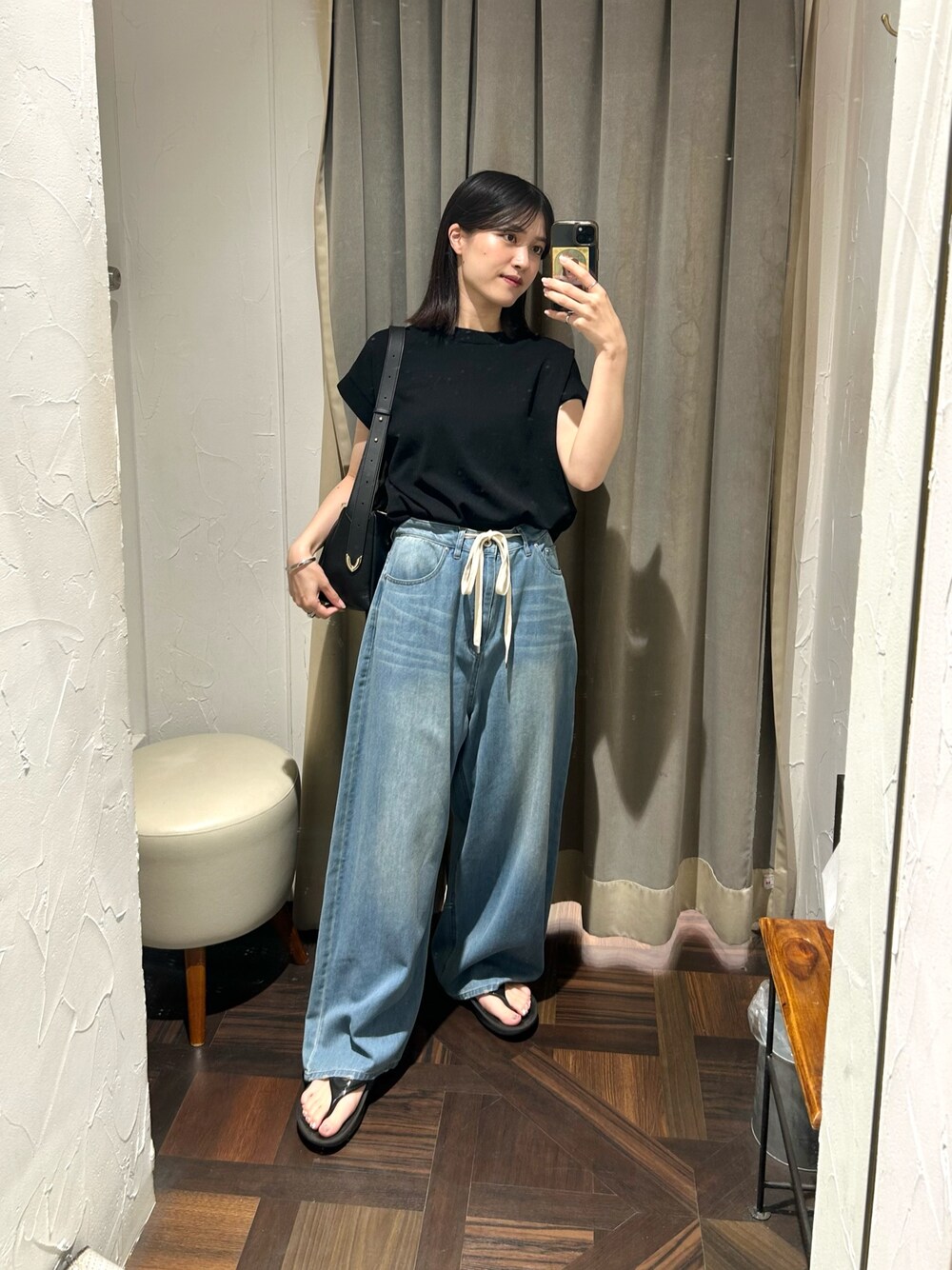 ブラック系のニット/セーター、ブルー系のデニムパンツ、ブラック系のボディバッグ/ウエストポーチを着用したレディースの夏コーディネートの1枚目の写真