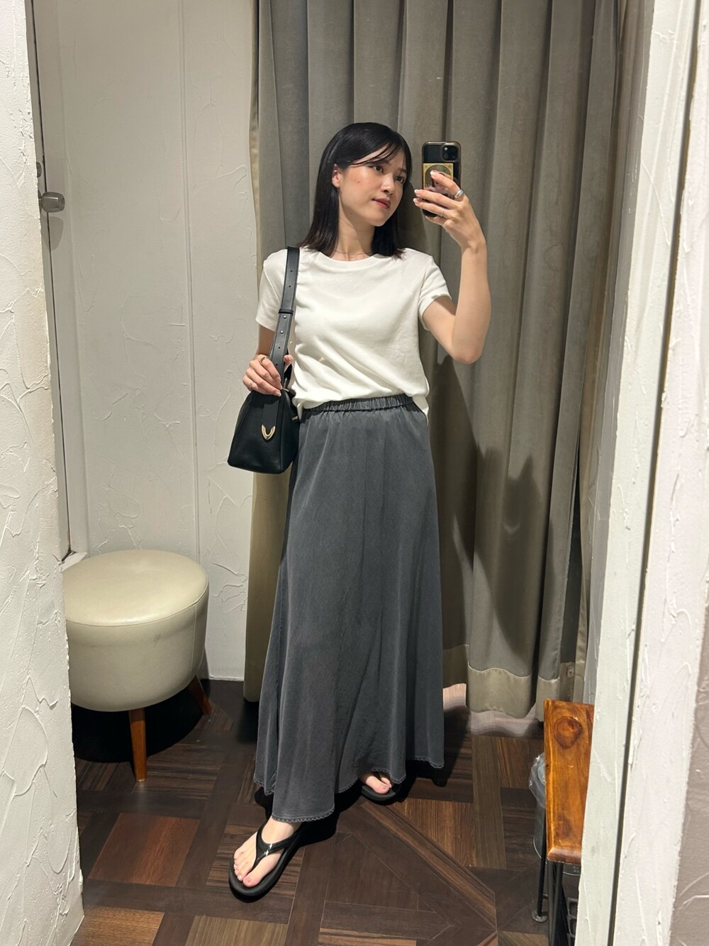 ブラック系のスカート、ブラック系のボディバッグ/ウエストポーチ、ホワイト系のTシャツ/カットソーを着用したレディースの夏コーディネートの1枚目の写真