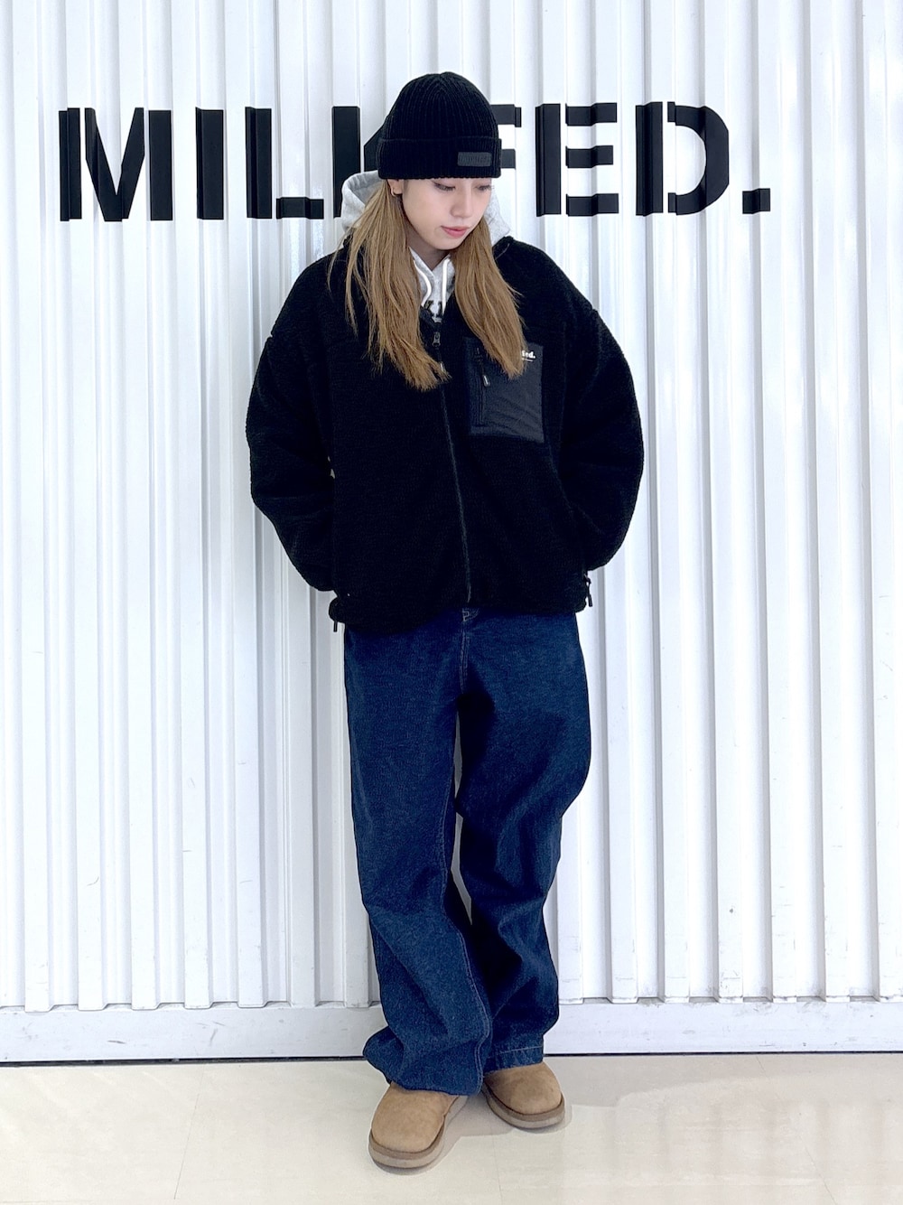 ブラック系のブルゾン、ブルー系のデニムパンツ、グレー系のパーカーを着用したレディースの冬コーディネートの1枚目の写真