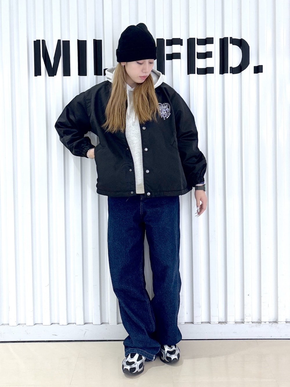 ブルー系のデニムパンツ、ブラック系のブルゾンを着用したレディースの冬コーディネートの1枚目の写真