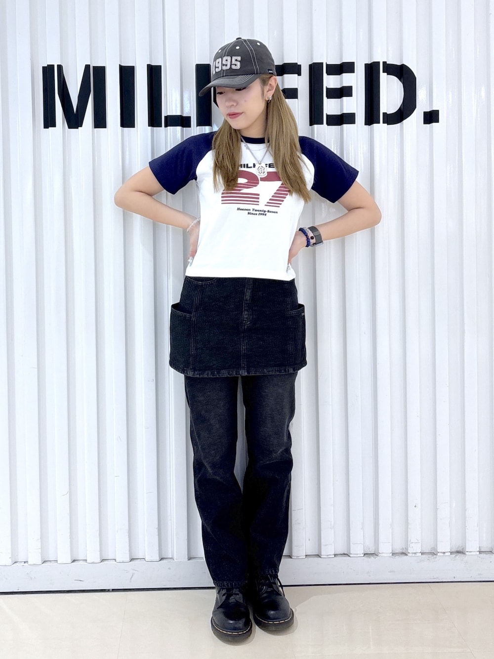ブラック系のデニムスカート、ブラック系のデニムパンツ、ホワイト系のTシャツ/カットソーを着用したレディースの夏コーディネートの1枚目の写真