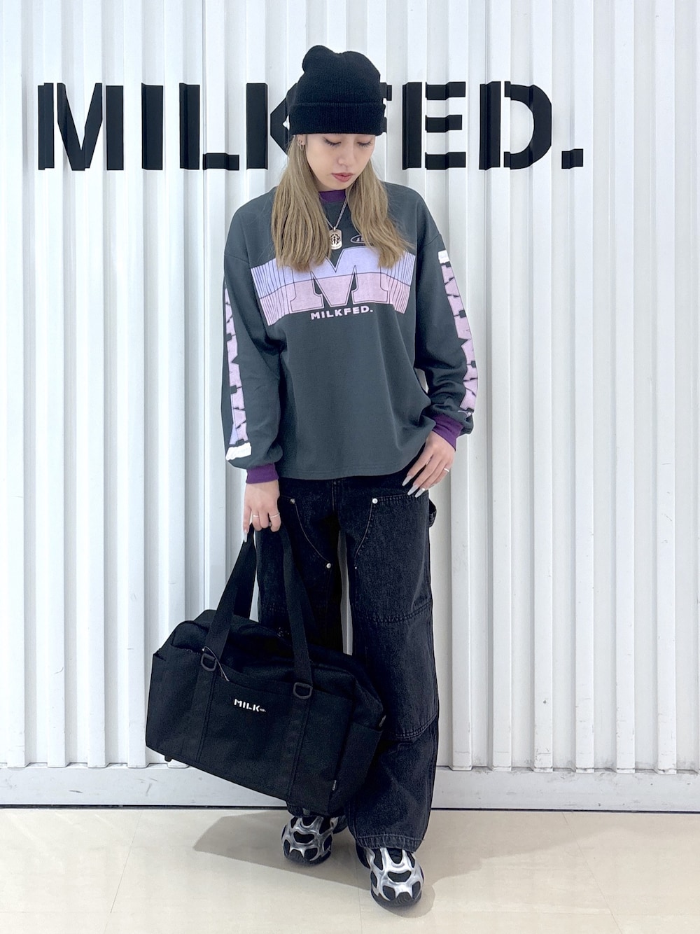 グレー系のTシャツ/カットソー、ブラック系のデニムパンツ、ブルー系のショルダーバッグを着用したレディースの冬コーディネートの1枚目の写真