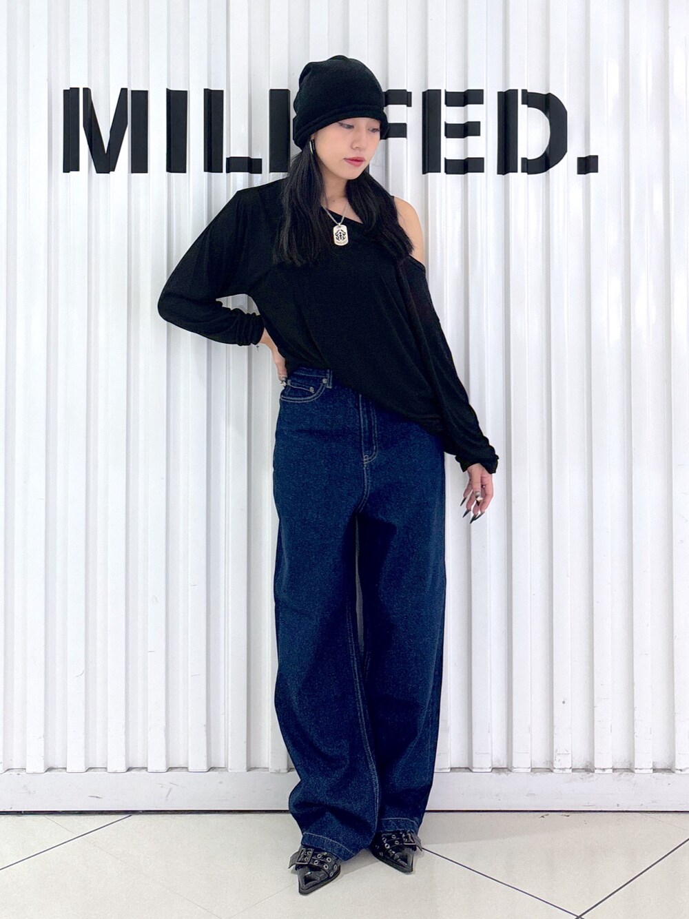 ブルー系のデニムパンツ、ブラック系のTシャツ/カットソー、ブラック系のニットキャップ/ビーニーを着用したレディースの秋コーディネートの1枚目の写真