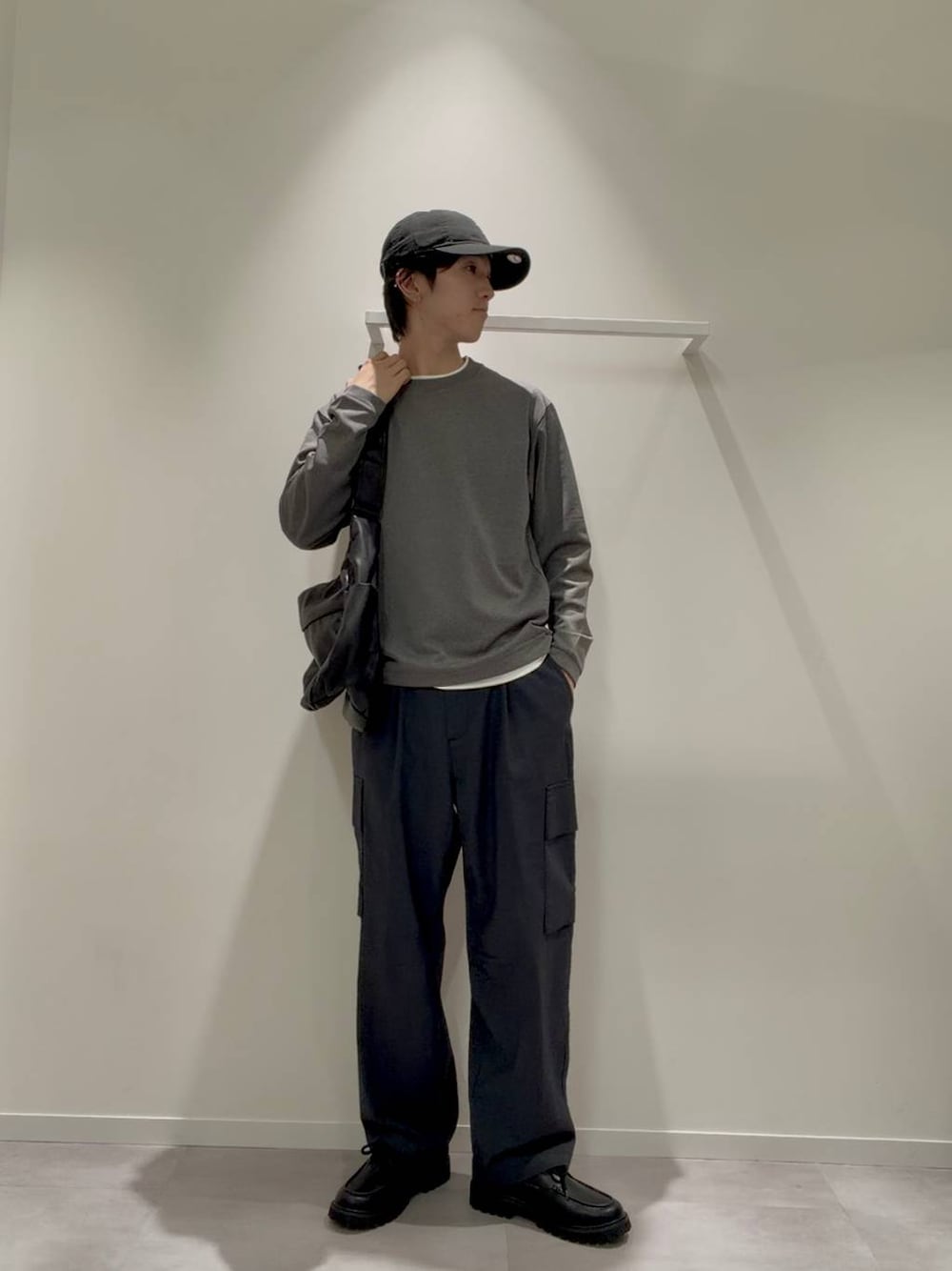 ブラック系のショルダーバッグ、グレー系のその他シューズ、ブルー系のデニムパンツを着用したメンズの秋コーディネートの1枚目の写真