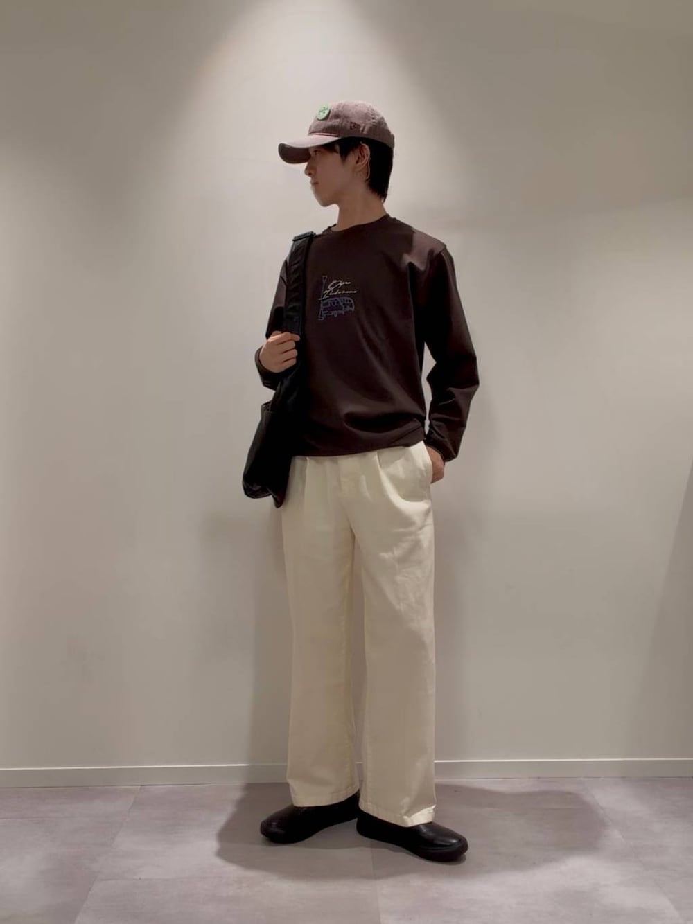 グレー系のその他シューズ、ホワイト系のその他パンツ、ブラック系のショルダーバッグを着用したメンズの秋コーディネートの1枚目の写真