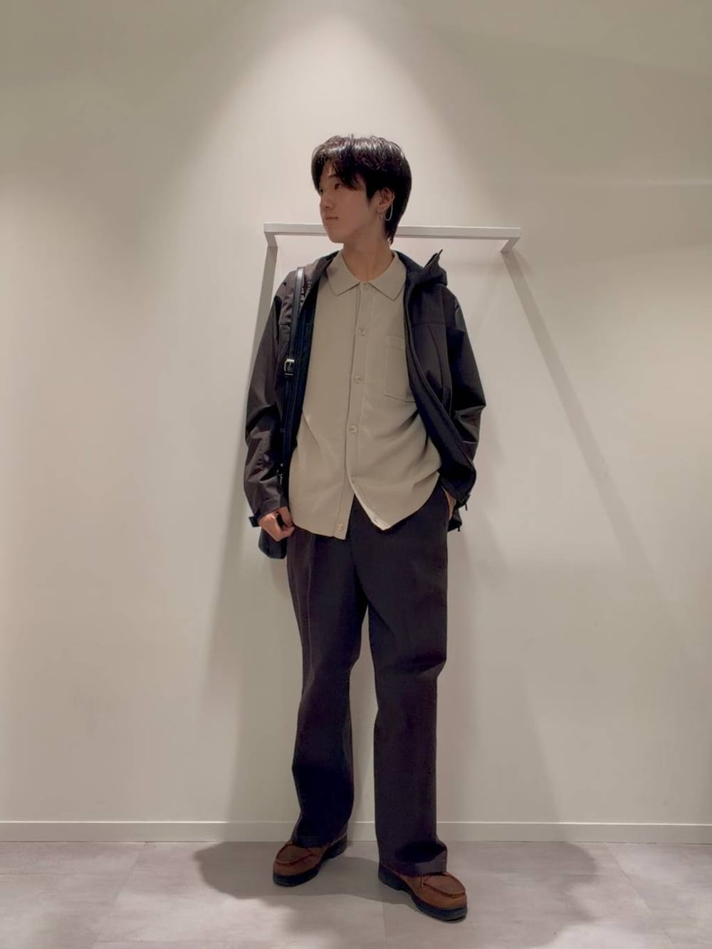 ブラック系のショルダーバッグ、ブラウン系のブルゾン、ベージュ系のカーディガン/ボレロを着用したメンズの秋コーディネートの1枚目の写真