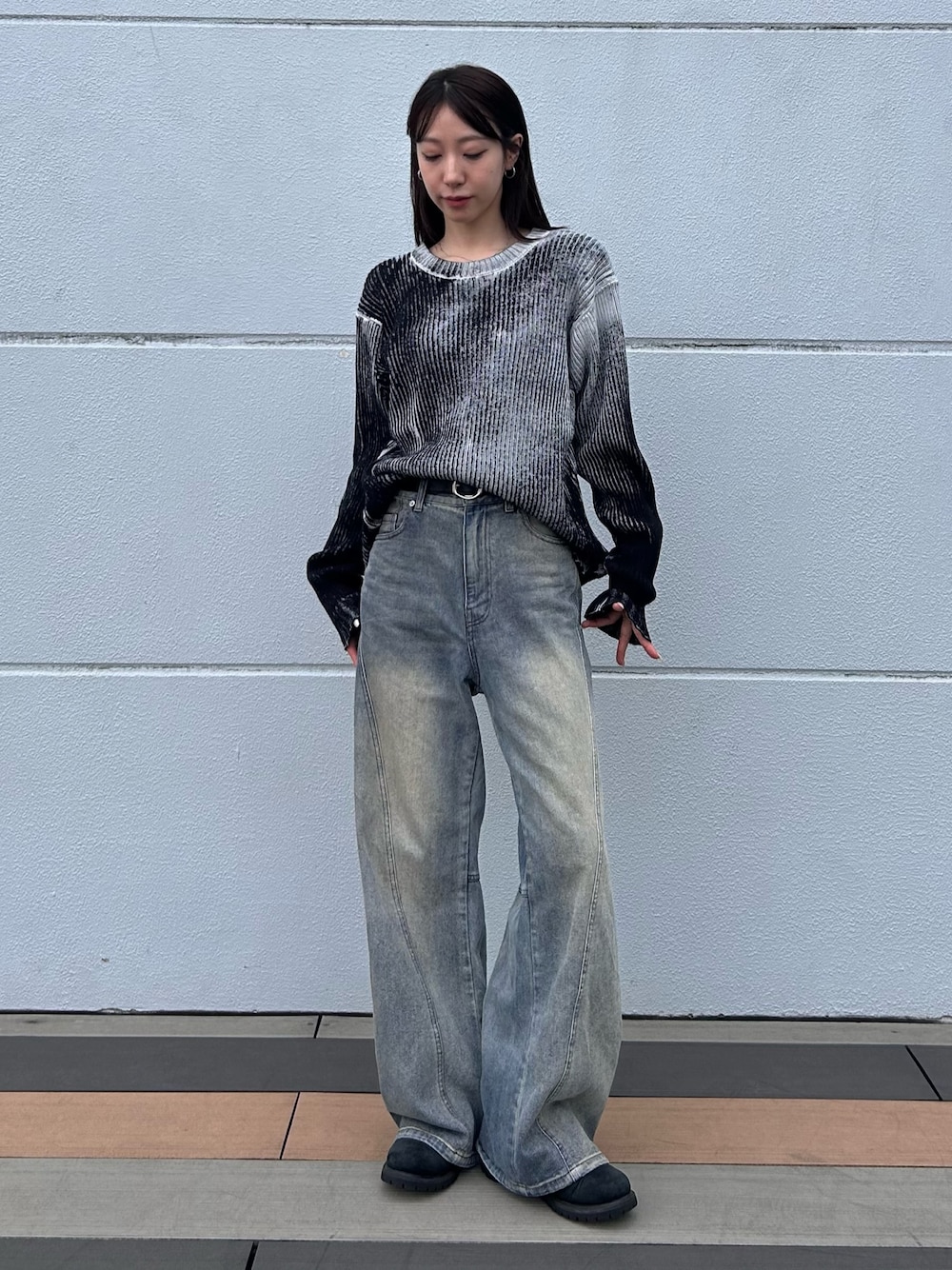 ブルー系のデニムパンツ、ホワイト系のニット/セーター、ブラック系のベルトを着用したレディースの秋コーディネートの1枚目の写真
