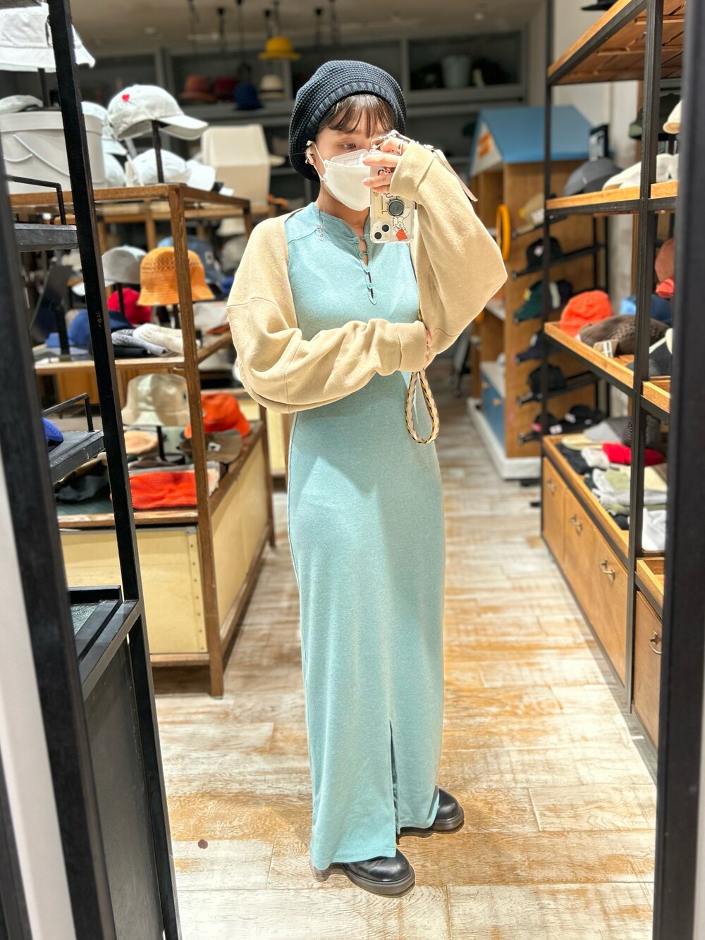 ベージュ系のカーディガン/ボレロ、ブラック系のブーツ、ブラック系のハンチング/ベレー帽を着用したレディースの春コーディネートの1枚目の写真