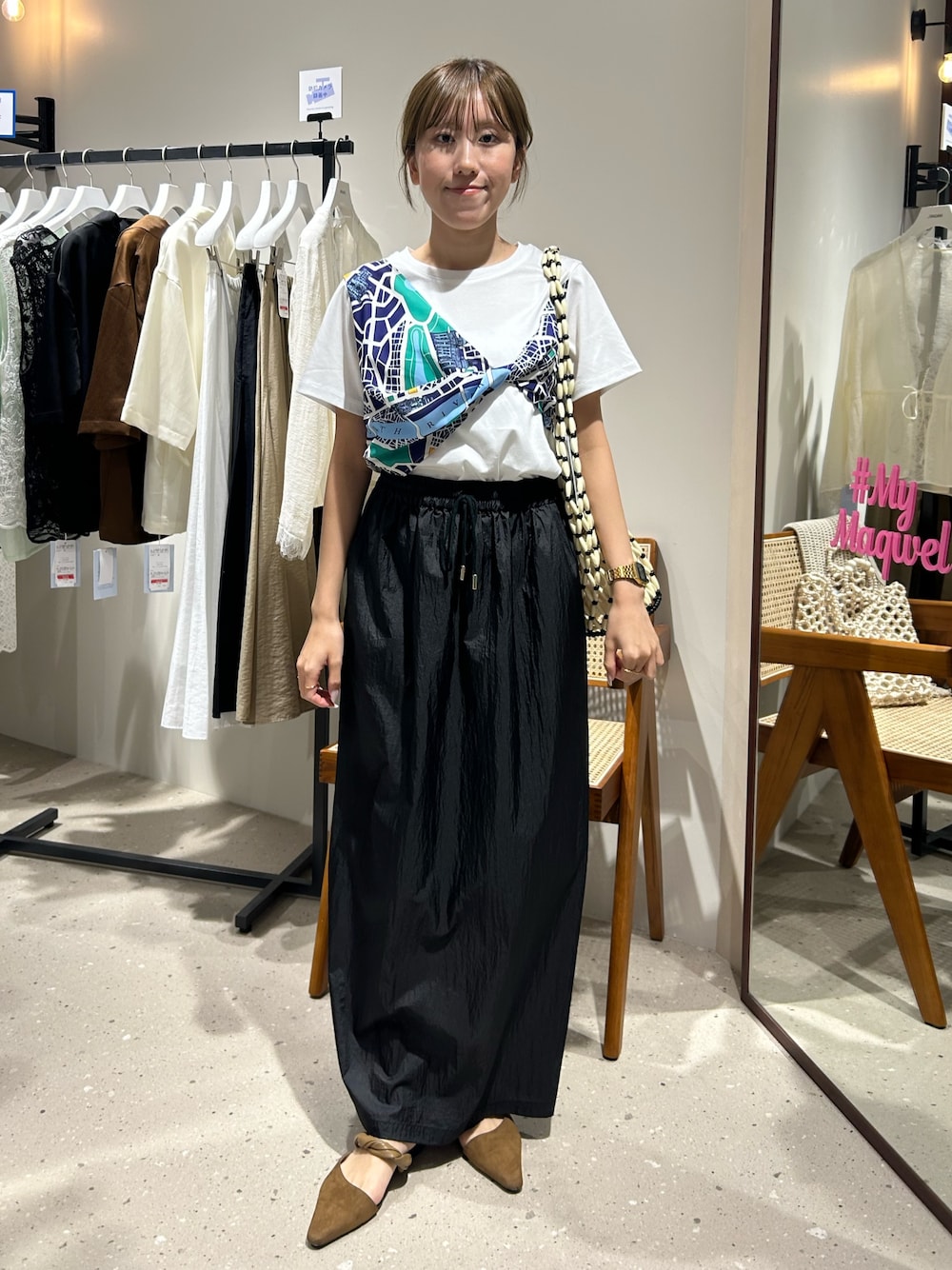 ブラック系のスカート、ホワイト系のTシャツ/カットソーを着用したレディースの夏コーディネートの1枚目の写真