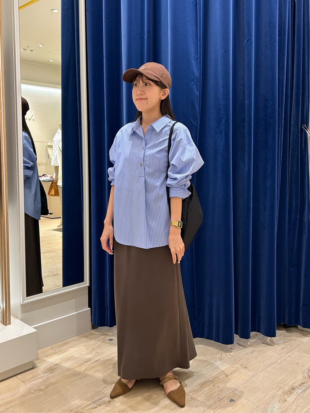 ブルー系のシャツ/ブラウス、ブラウン系のスカート、ブラック系のショルダーバッグを着用したレディースの秋コーディネートの1枚目の写真