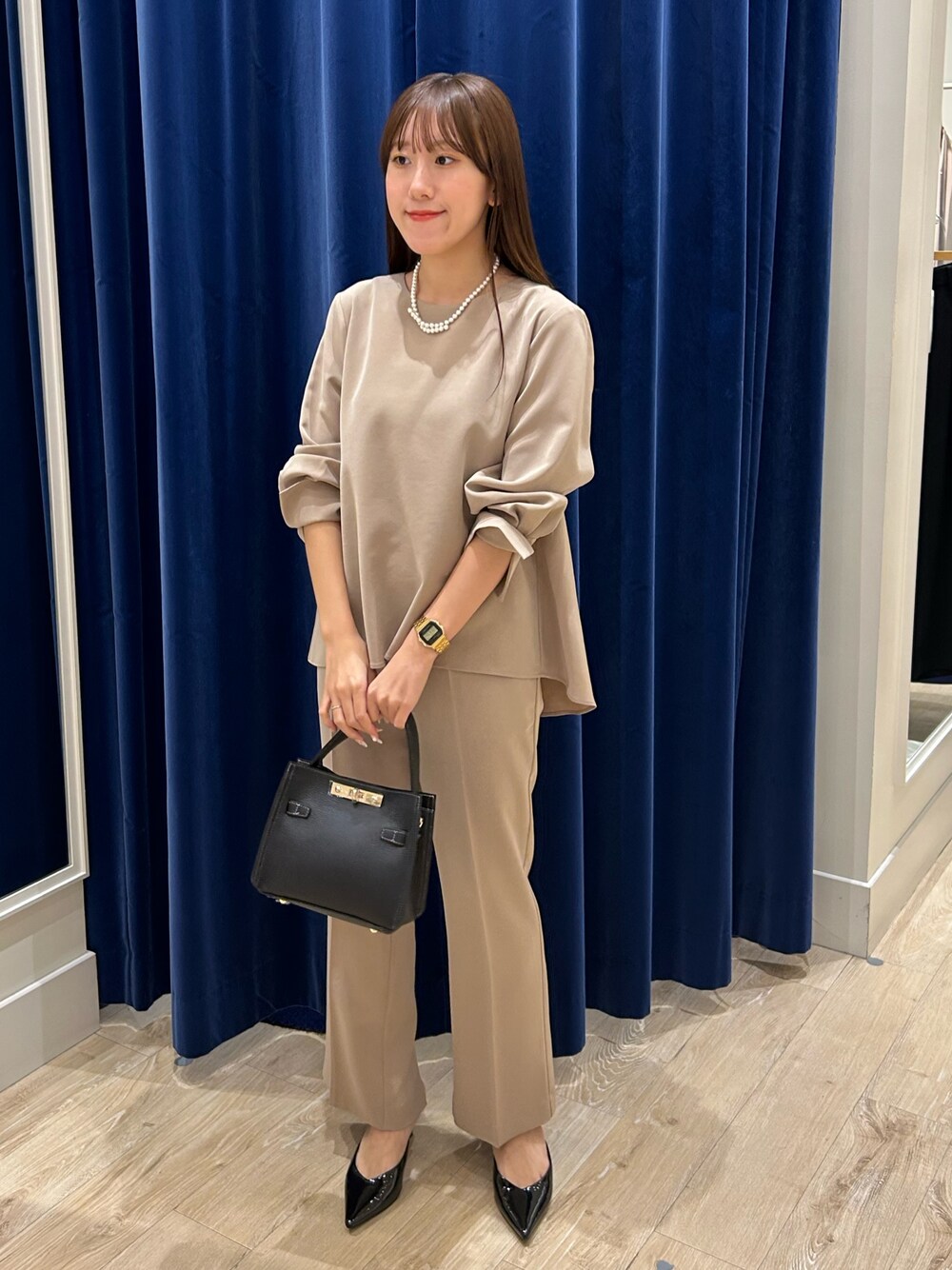 ベージュ系のその他パンツ、ベージュ系のシャツ/ブラウス、ブラック系のショルダーバッグを着用したレディースの秋コーディネートの1枚目の写真
