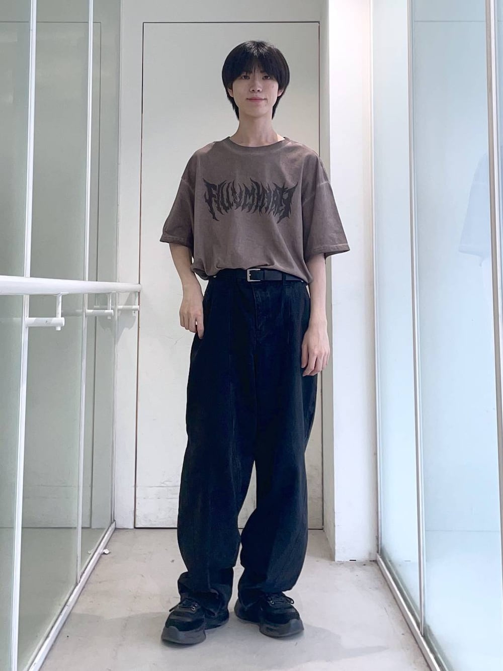 ブラック系のデニムパンツ、ブラウン系のTシャツ/カットソー、ブラック系のベルトを着用したメンズの夏コーディネートの1枚目の写真