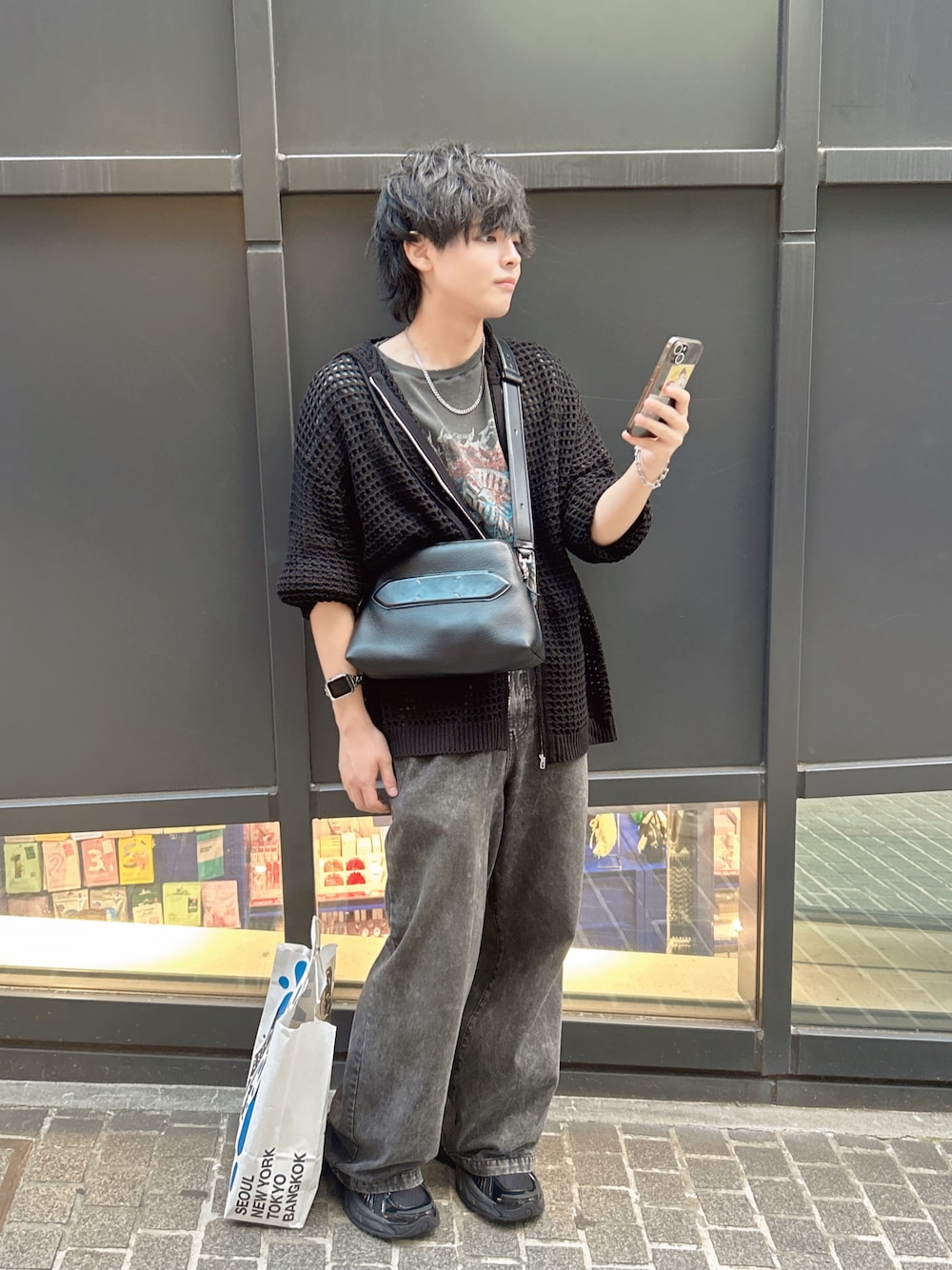 ブラック系のスラックス、ブラック系のスニーカー、ブラック系のショルダーバッグを着用したメンズの秋コーディネートの1枚目の写真