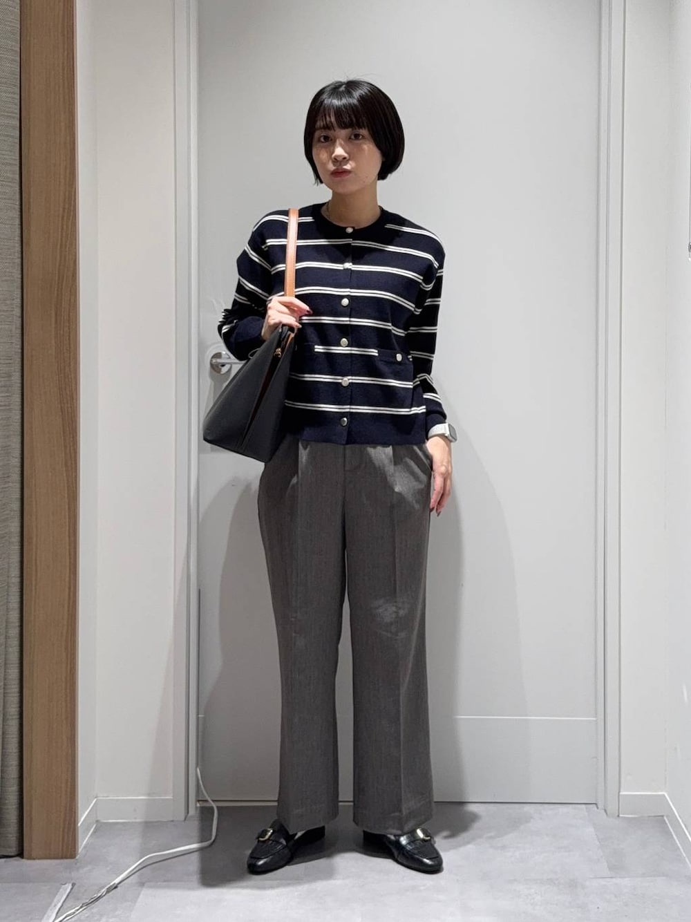 ブラック系のトートバッグ、グレー系のその他パンツ、ブルー系のカーディガン/ボレロを着用したレディースの秋コーディネートの1枚目の写真