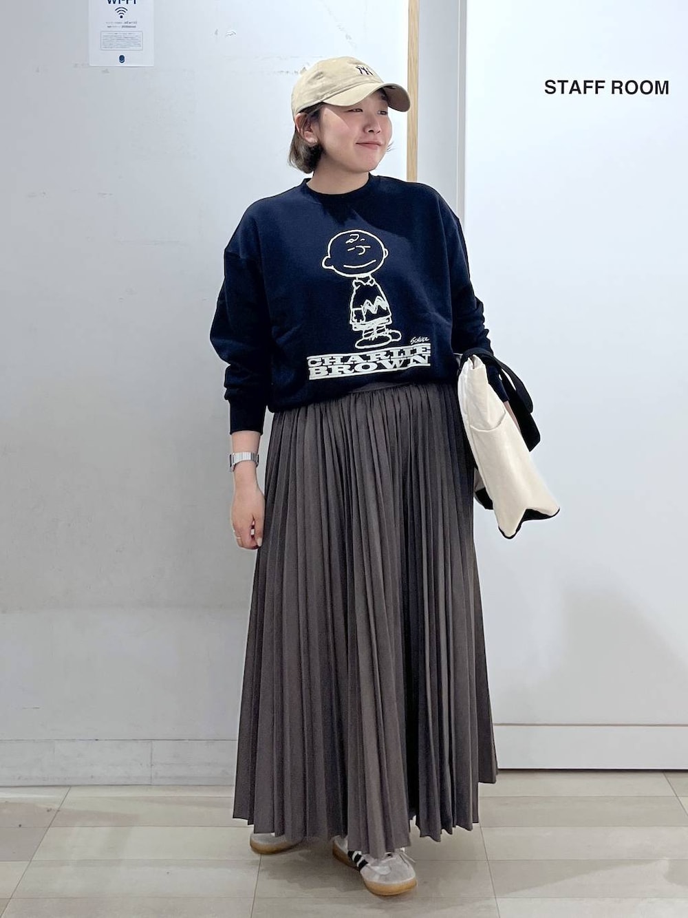 ホワイト系のトートバッグ、ブルー系のスウェット、ベージュ系のスカートを着用したレディースの秋コーディネートの1枚目の写真