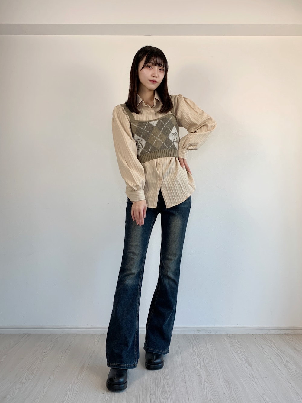 ブルー系のデニムパンツ、グレー系のニット/セーター、ベージュ系のシャツ/ブラウスを着用したレディースの秋コーディネートの1枚目の写真