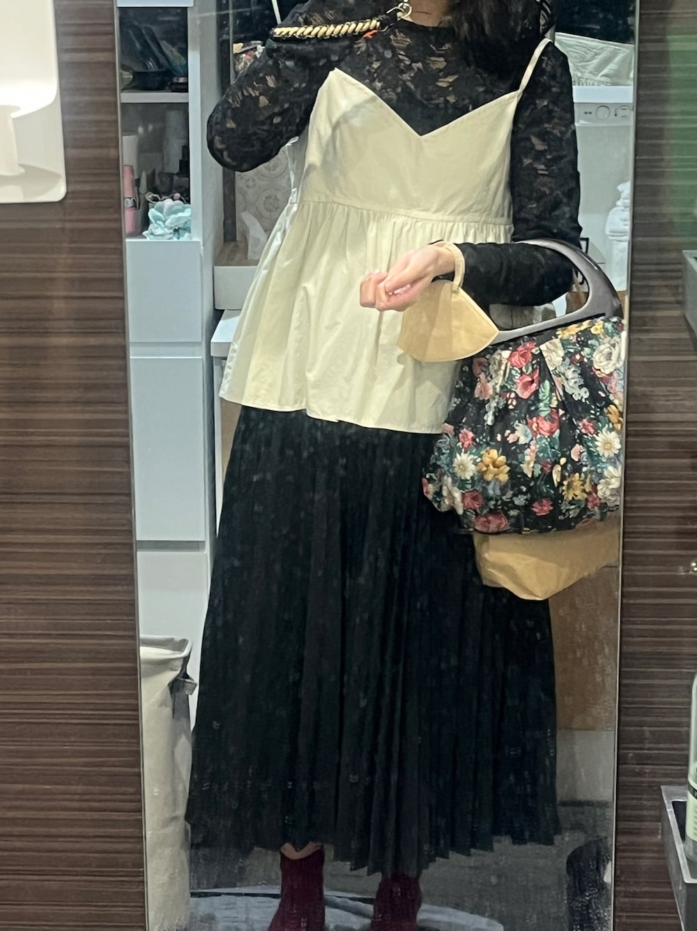 グレー系のスカート、ホワイト系のその他トップス、ブラック系のトップスを着用したレディースの秋コーディネートの1枚目の写真