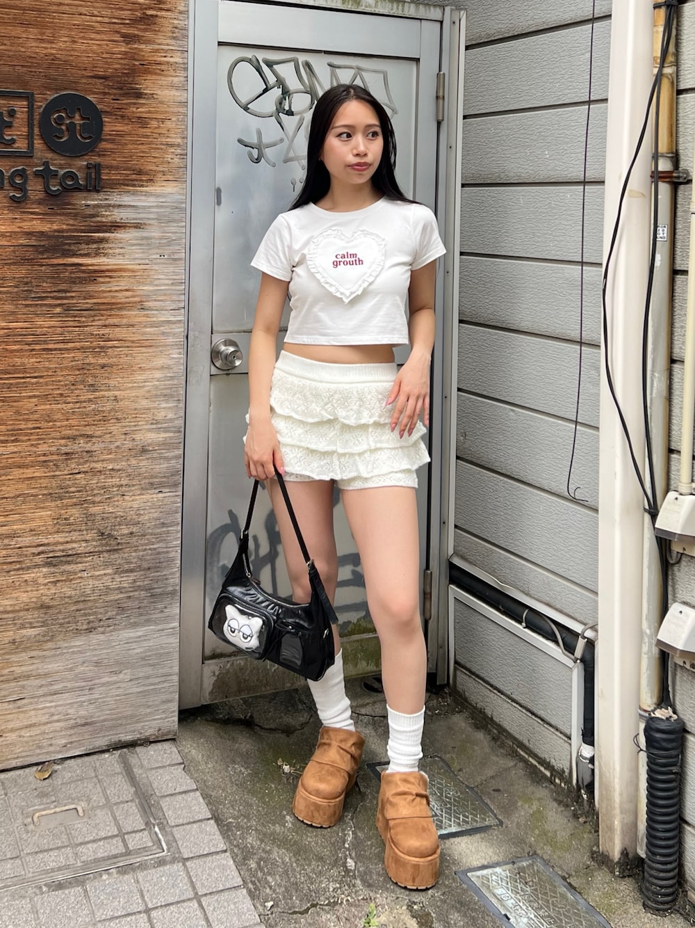 ホワイト系のTシャツ/カットソー、ホワイト系のスカート、ブラック系のハンドバッグを着用したレディースの秋コーディネートの1枚目の写真
