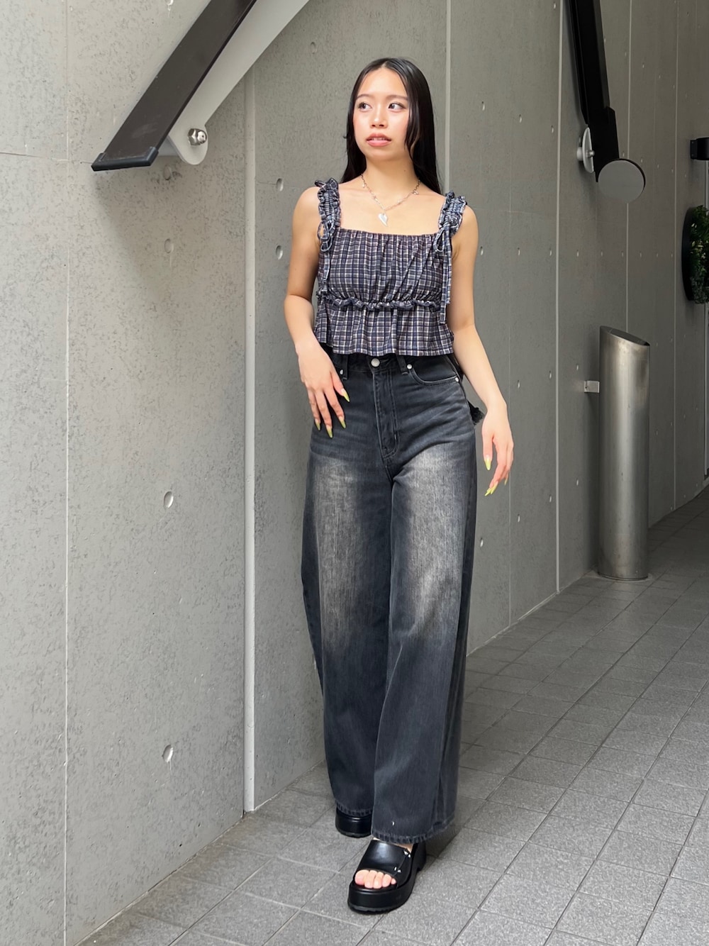 ブラウン系のタンクトップ、ブラック系のデニムパンツ、ブラック系のサンダルを着用したレディースの夏コーディネートの1枚目の写真