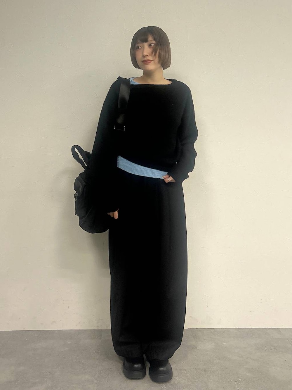 ブラック系のスラックス、ブラック系のトートバッグ、ブラック系のニット/セーターを着用したレディースの秋コーディネートの1枚目の写真