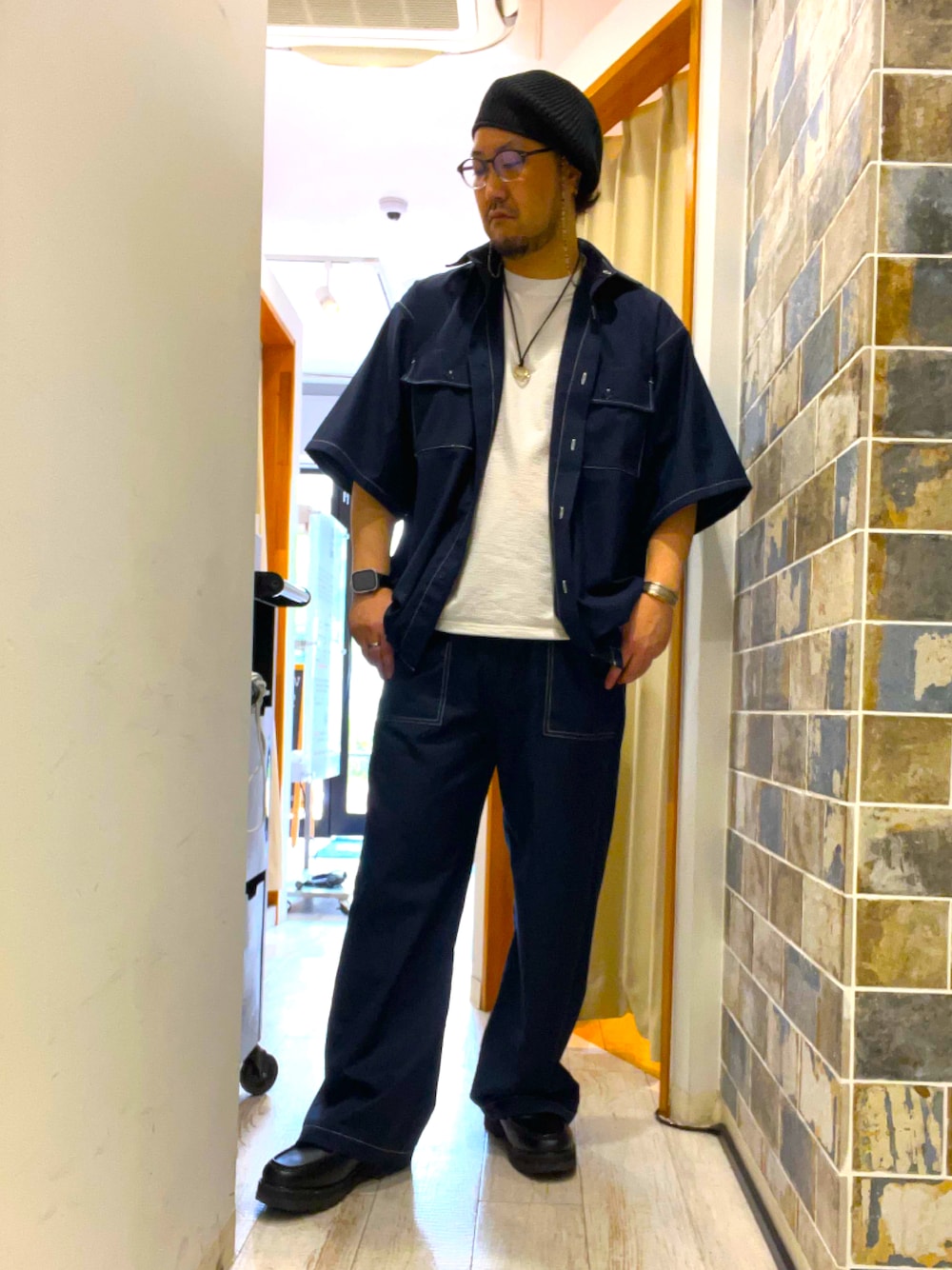 ブラック系のローファー、ブルー系のスラックス、ホワイト系のTシャツ/カットソーを着用したメンズの夏コーディネートの1枚目の写真
