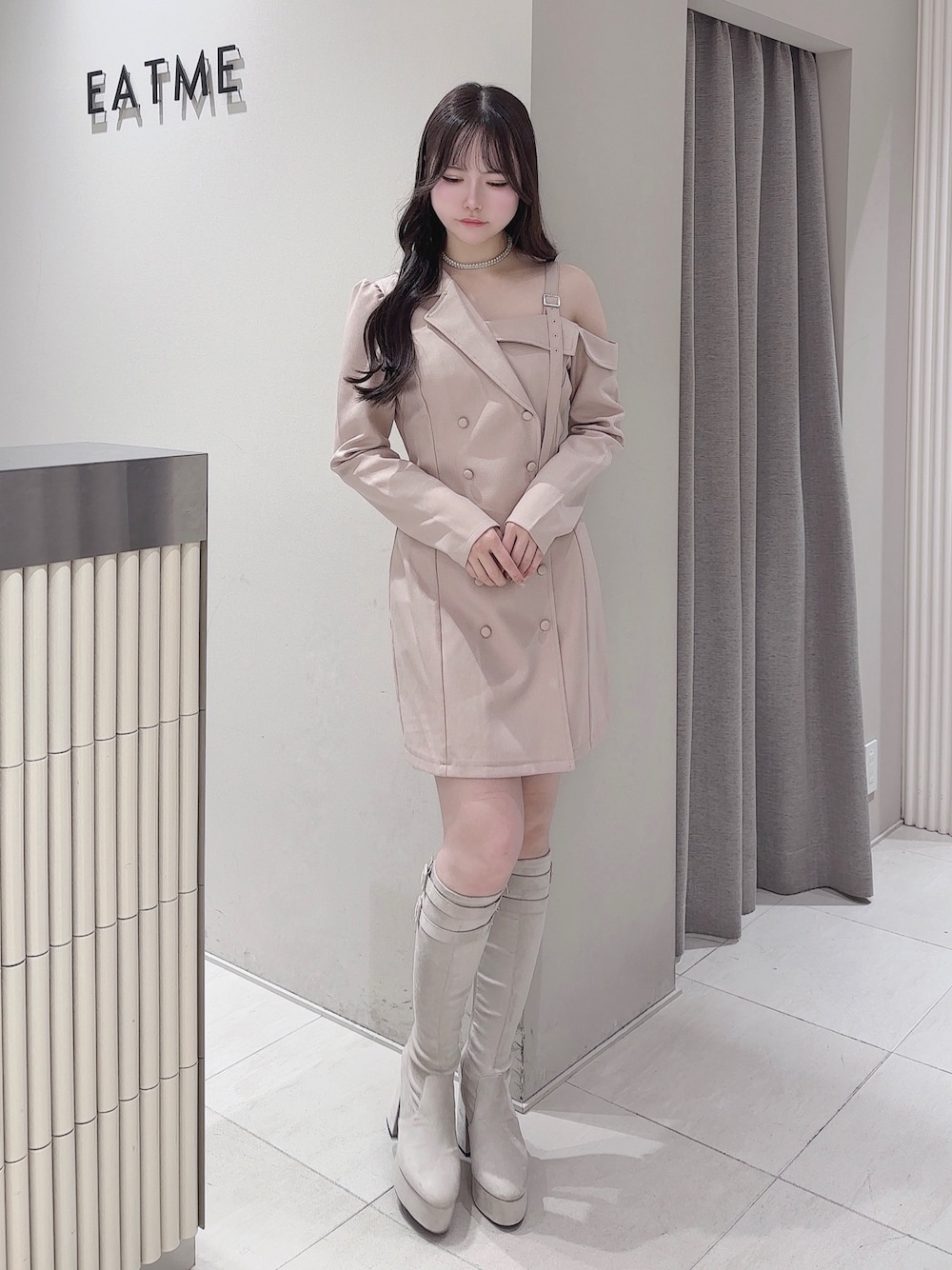 ピンク系のワンピース、ホワイト系のブーツ、シルバー系のネックレスを着用したレディースの冬コーディネートの1枚目の写真