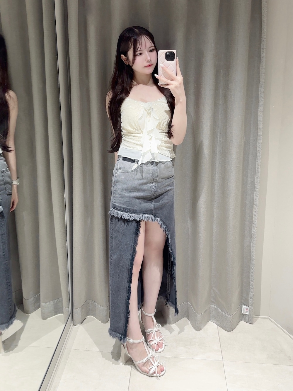 ブラック系のデニムスカート、ホワイト系のキャミソール、ホワイト系のサンダルを着用したレディースの夏コーディネートの1枚目の写真