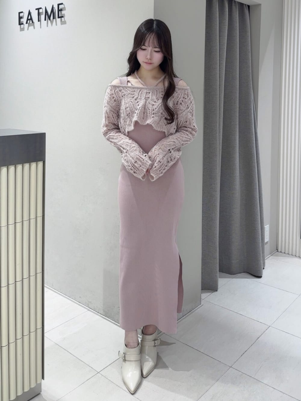 ピンク系のワンピース、ホワイト系のブーツを着用したレディースの冬コーディネートの1枚目の写真