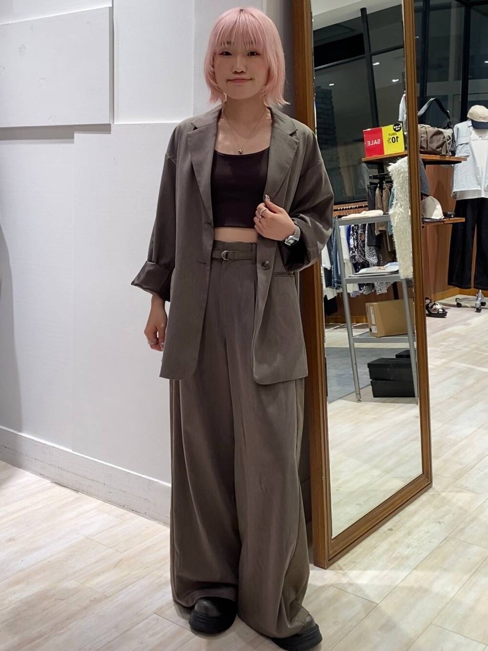 ブラック系のブーツ、ブラウン系のキャミソール、ブラウン系のスラックスを着用したレディースの夏コーディネートの1枚目の写真