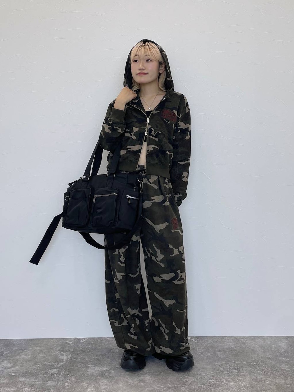 ブラック系のスニーカー、ブラック系のキャミソール、その他のスウェットパンツを着用したレディースの秋コーディネートの1枚目の写真