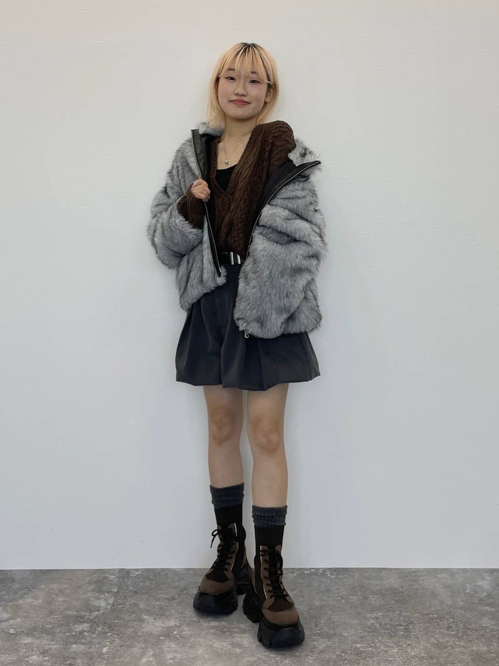 ブラウン系のブーツ、ブラック系のキャミソール、ブラウン系のニット/セーターを着用したレディースの秋コーディネートの1枚目の写真