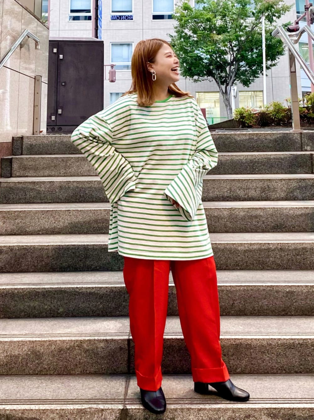 グリーン系のTシャツ/カットソー、レッド系のその他パンツ、ブラック系のブーツを着用したレディースの秋コーディネートの1枚目の写真