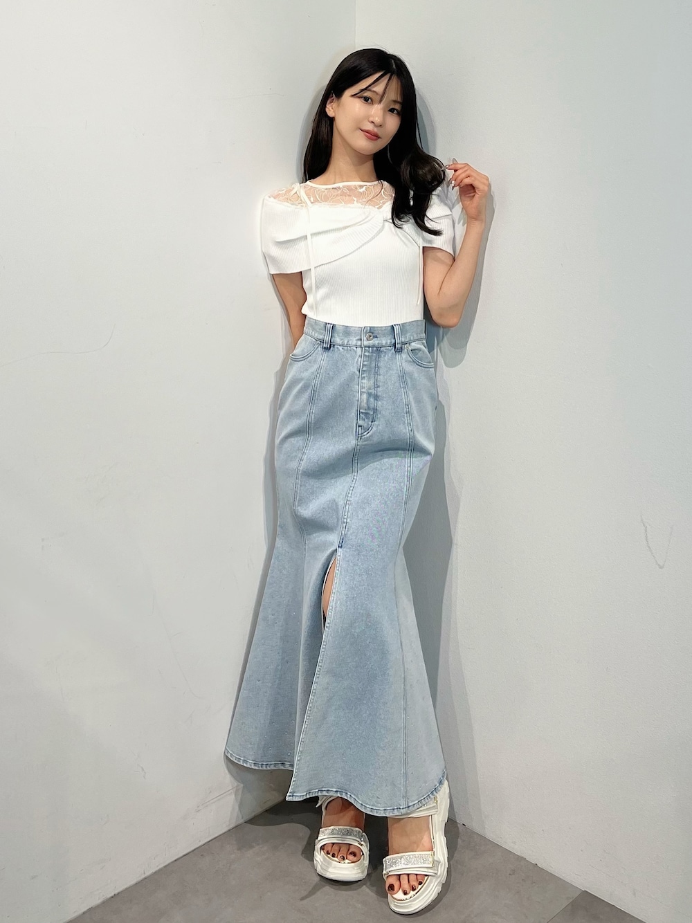 ホワイト系のニット/セーター、ブルー系のスカート、シルバー系のサンダルを着用したレディースの夏コーディネートの1枚目の写真