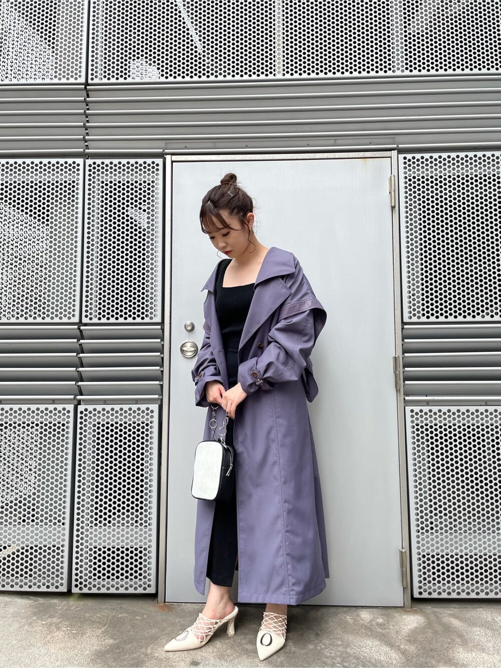 ブラック系のニット/セーター、ブラック系のスカート、ホワイト系のパンプスを着用したレディースの夏コーディネートの1枚目の写真