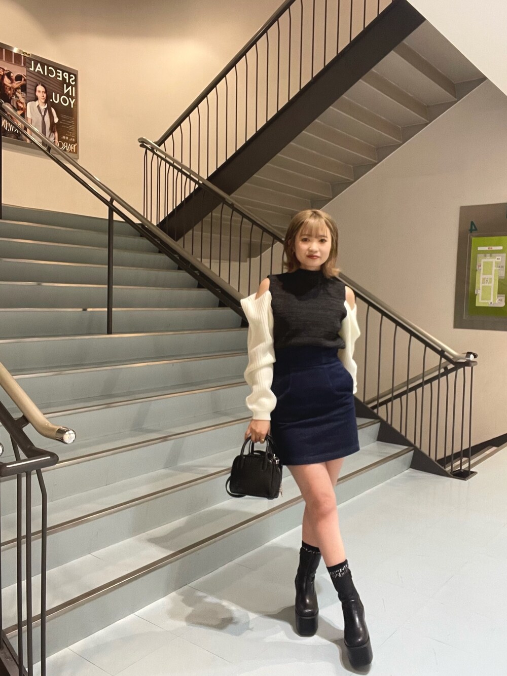 ブラック系のボストンバッグ、ブラック系のニット/セーター、ブラック系のブーツを着用したレディースの秋コーディネートの1枚目の写真