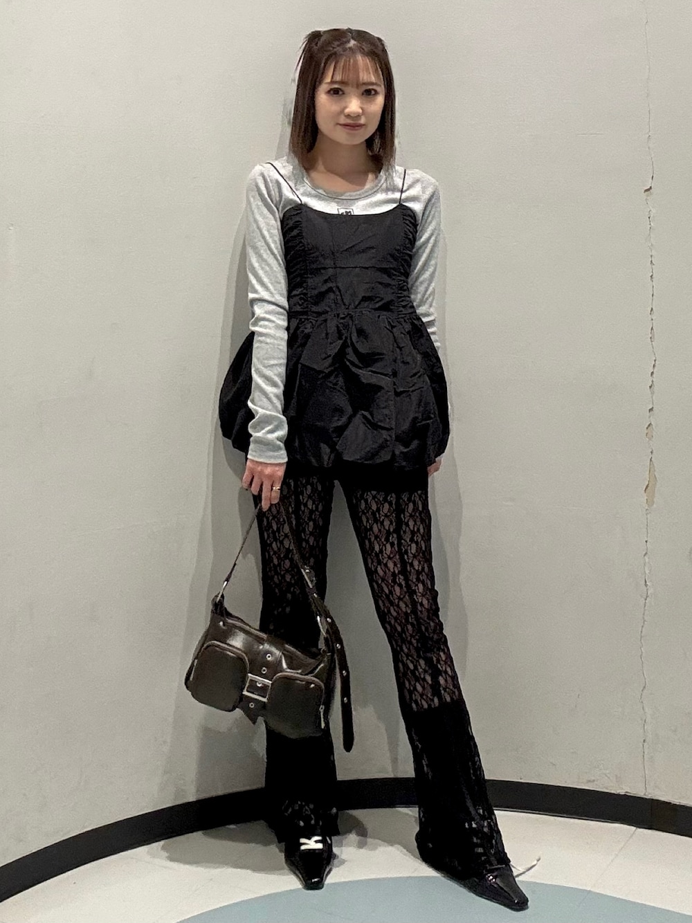 ブラック系のキャミソール、ブラウン系のハンドバッグ、グレー系のTシャツ/カットソーを着用したレディースの春コーディネートの1枚目の写真