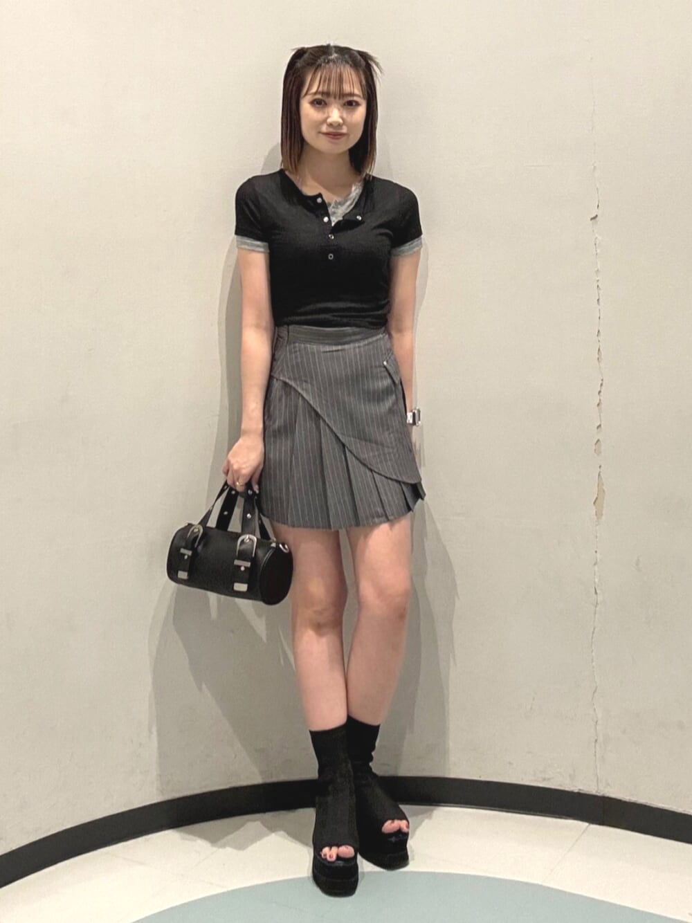 ブラック系のハンドバッグ、ブラック系のサンダル、ブラック系のTシャツ/カットソーを着用したレディースの夏コーディネートの1枚目の写真