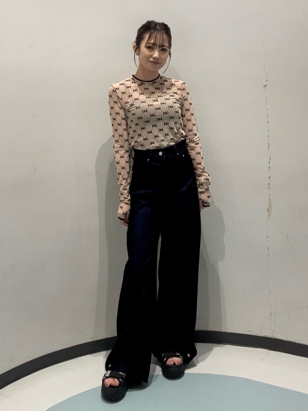 ブラック系のデニムパンツ、ベージュ系のTシャツ/カットソー、ブラック系のサンダルを着用したレディースの夏コーディネートの1枚目の写真