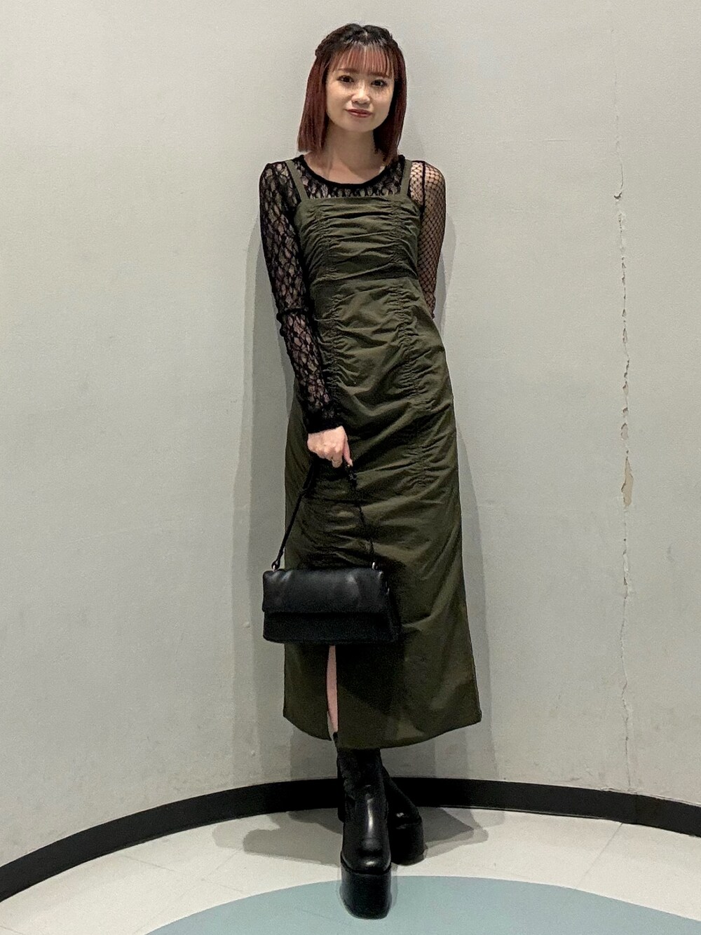 ブラック系のハンドバッグ、ブラック系のTシャツ/カットソー、ブラック系のブーツを着用したレディースの秋コーディネートの1枚目の写真