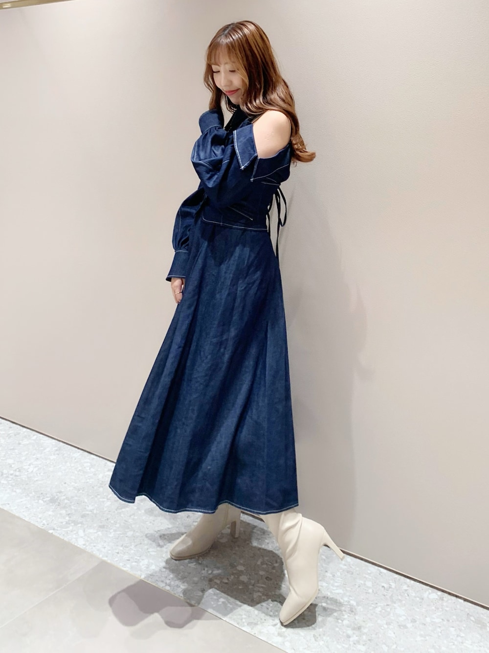 ホワイト系のブーツ、ブルー系のワンピースを着用したレディースの秋コーディネートの1枚目の写真