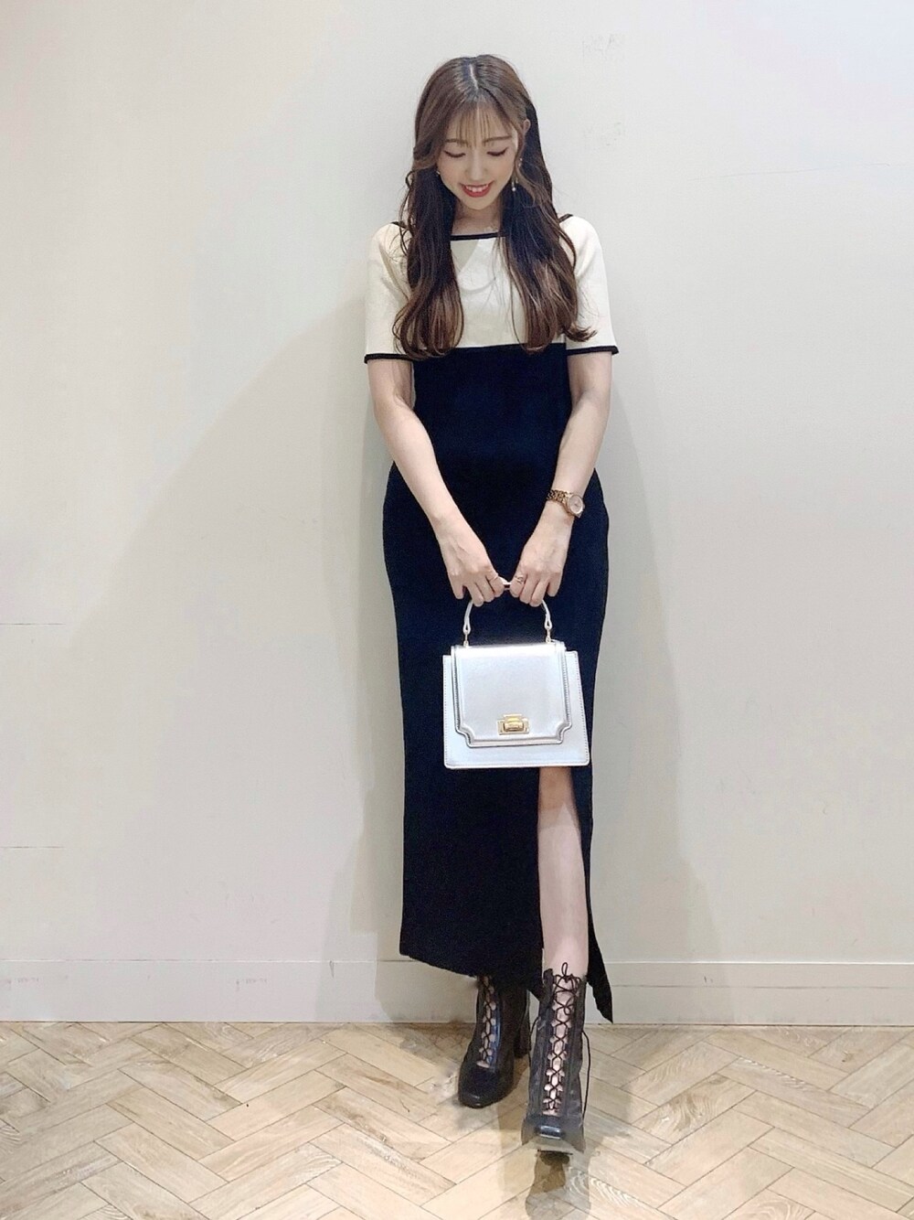 ブラック系のワンピース、シルバー系のハンドバッグ、ブラック系のブーツを着用したレディースの夏コーディネートの1枚目の写真