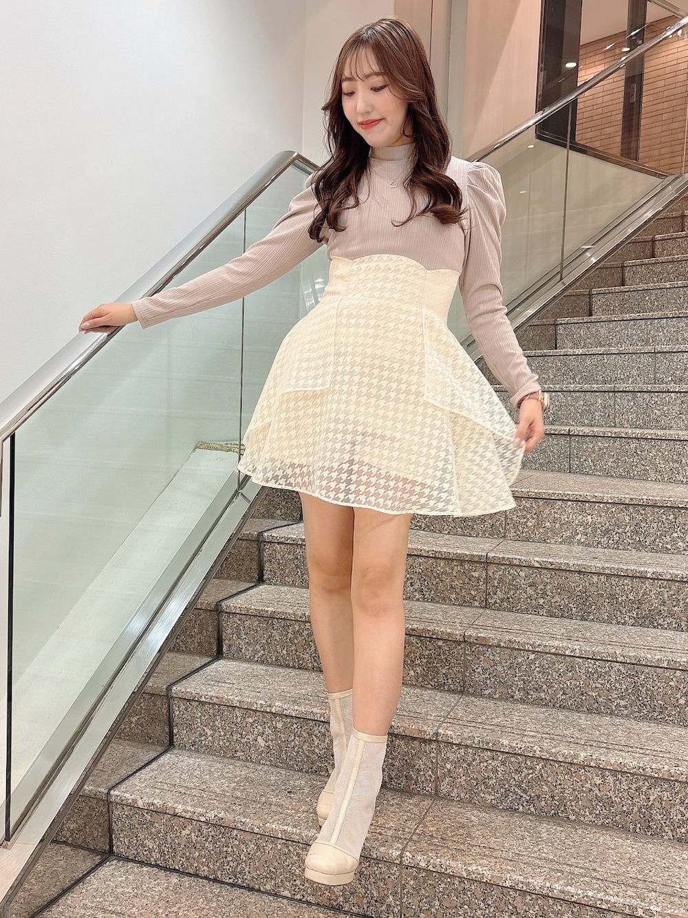 ホワイト系のブーツ、ベージュ系のワンピースを着用したレディースの冬コーディネートの1枚目の写真