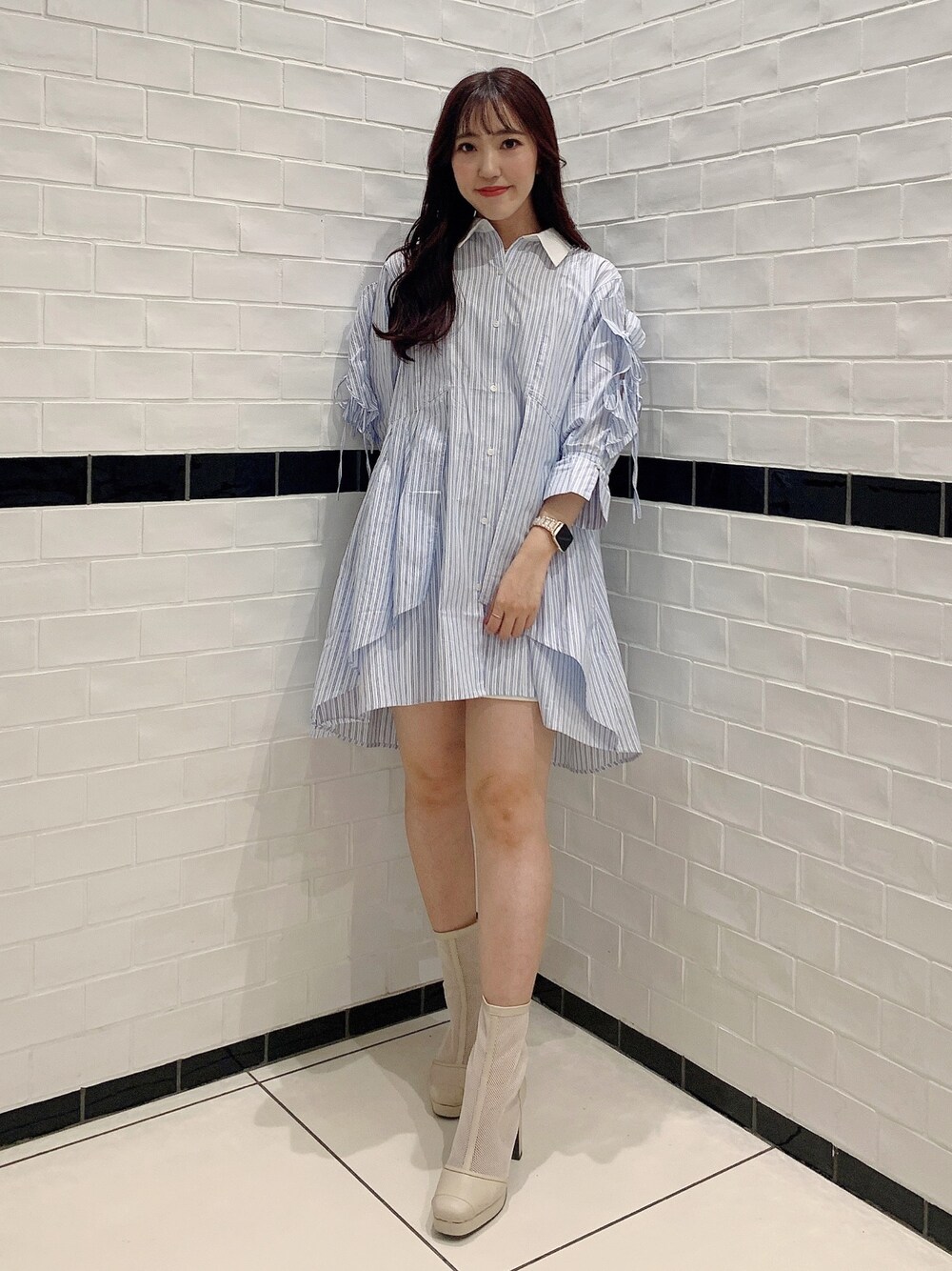 ブルー系のシャツワンピース、ホワイト系のブーツ、ホワイト系のキャミソールを着用したレディースの春コーディネートの1枚目の写真