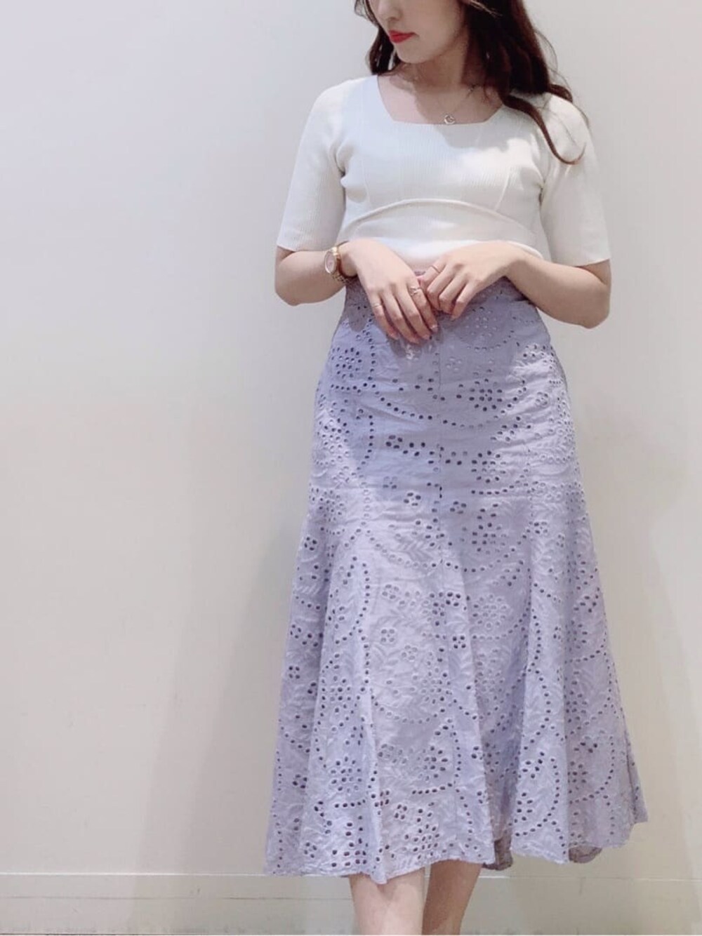 ホワイト系のニット/セーター、パープル系のスカート、ベージュ系のサンダルを着用したレディースの春コーディネートの1枚目の写真