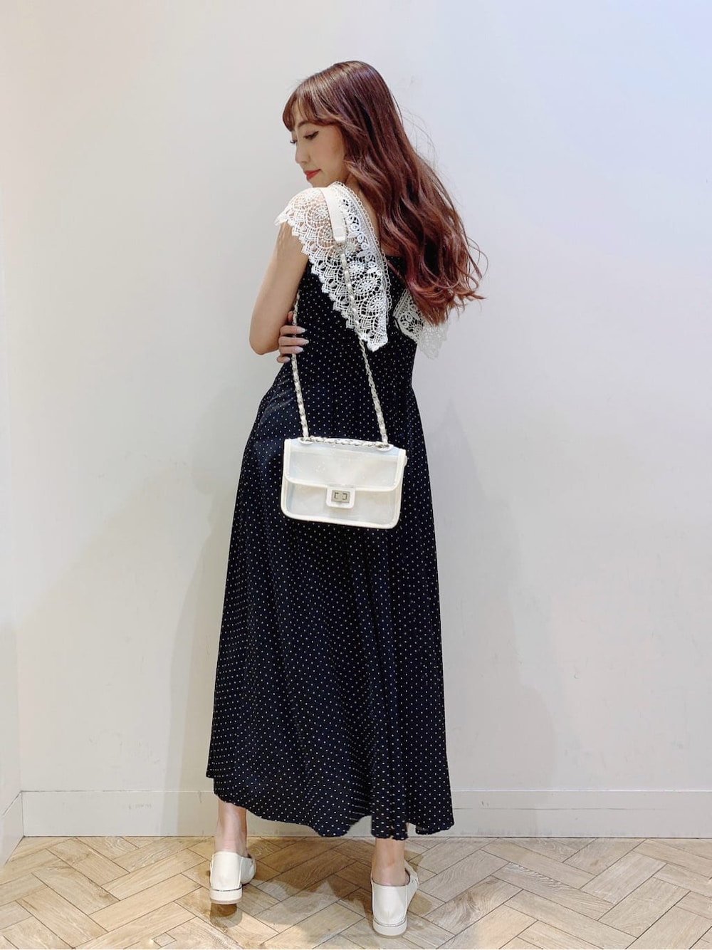 ホワイト系のパンプス、ブラック系のワンピース、ホワイト系のショルダーバッグを着用したレディースの春コーディネートの1枚目の写真